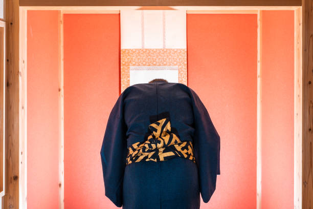 habitación tradicional japonesa con ventana de puerta corredera y alcoba con pergamino colgante y color rojo con el hombre en kimono inclinado - obi sash fotografías e imágenes de stock