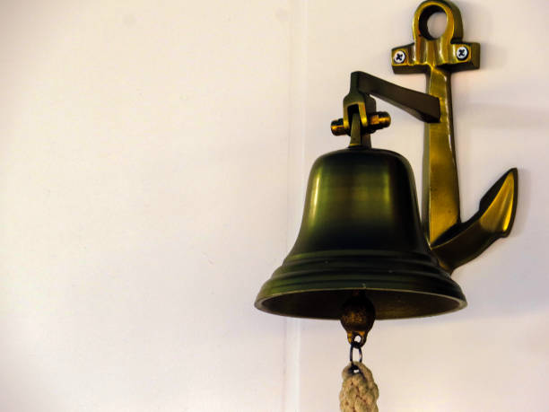 Bronze bell and anchor with copy space Bronze bell and anchor with copy space school handbell stock pictures, royalty-free photos & images