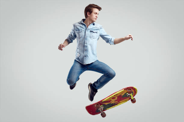 istock Handsome hipster man in jeans jacket doing the flip on stylish skateboard 1158723541