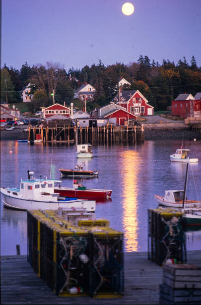 istock New England Harbor at Dusk with Bright Moon and Reflection in the Water 1158726292