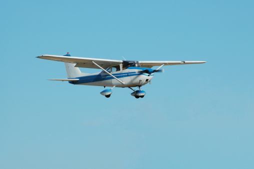 Private four passenger airplane flying on a clear, bright day. Cessna 172.