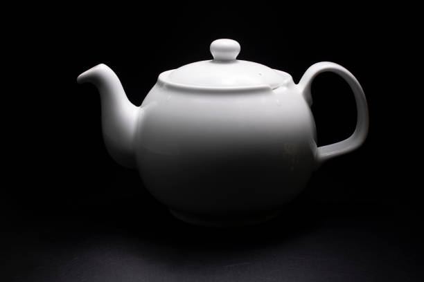 istock White porcelain teapot. Traditional design. Black background. 1158729930