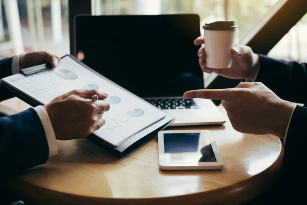 istock Businessmen pointed out the company performance chart on the table during a strategy discussion and drank coffee in the morning in the office. 1158730656