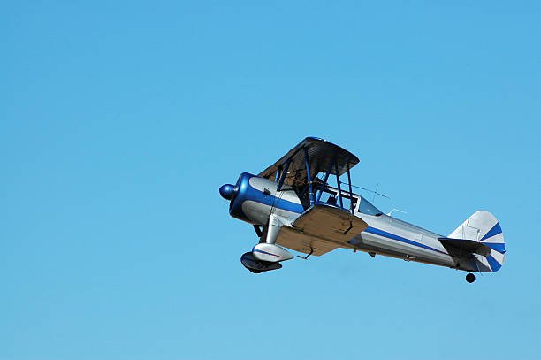 biplane Stearman Kaydet flying in clear blue sky