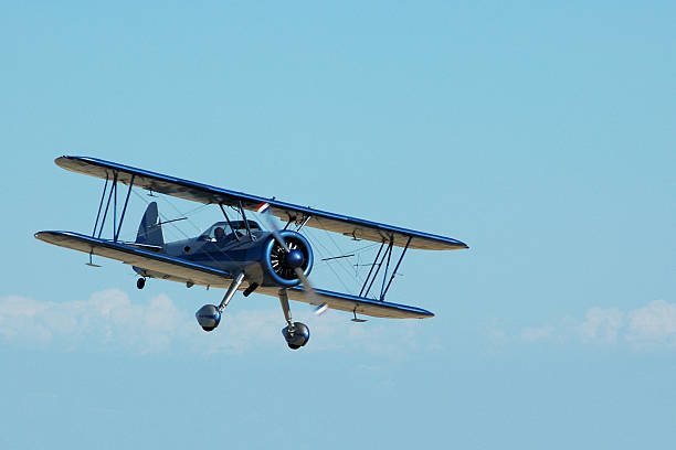 biplane Stearman Kadet flying in sky Shearman Kadet biplane. Originally a World War II trainer. Most used as crop dusters or stunt planes today. aerobatics photos stock pictures, royalty-free photos & images