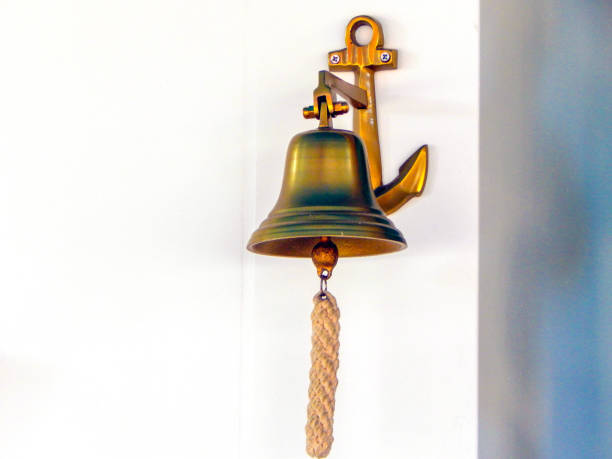 istock Metal bell with rope on white wall 1158732311