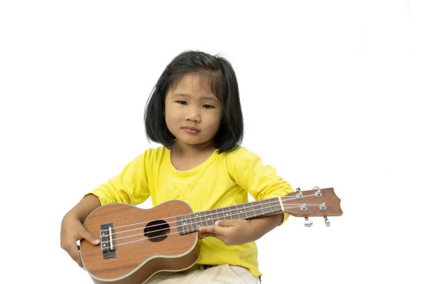 istock Little girl playing ukulele on white background 1158736828