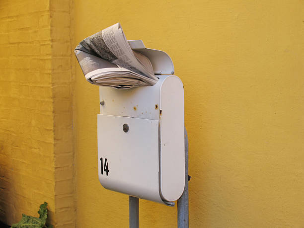 Yellow iron mailbox on white wall. Close-up photo of mail box with empty sign in Germany, Europe
