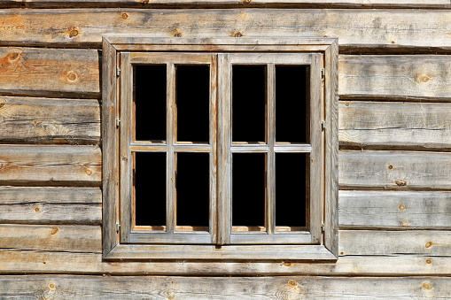 Rustic style aged  window in wooden village rural  home wall. Glass isolated with black.