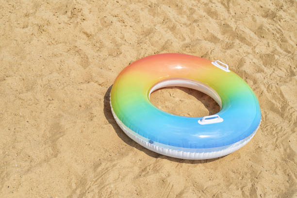 tubo da bagno o anello di gomma sulla sabbia - swimming tube inflatable circle foto e immagini stock