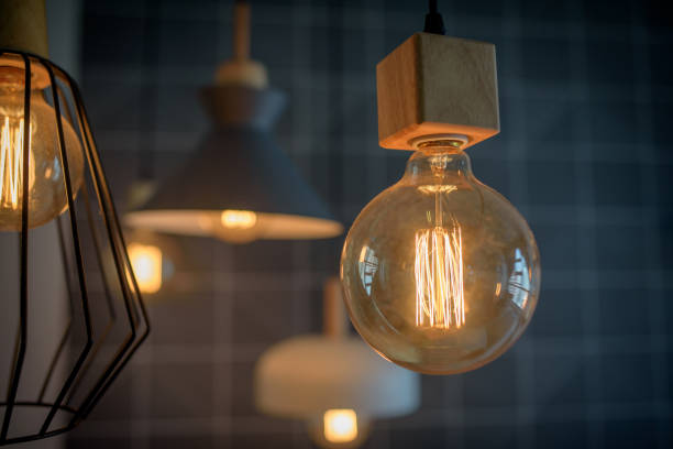 istock Vintage style light bulb hang in darkness 1158743081