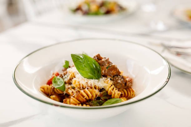 Fusilli Pasta with beef cheek ragu, onion, tomato, and basil