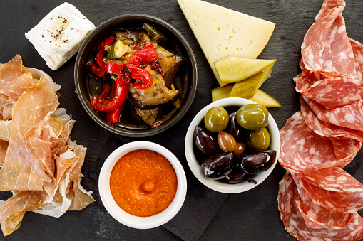 Italian Food - Sopressa And Prosciutto Platter with marinated vegetables, olives, romesco and lavosh