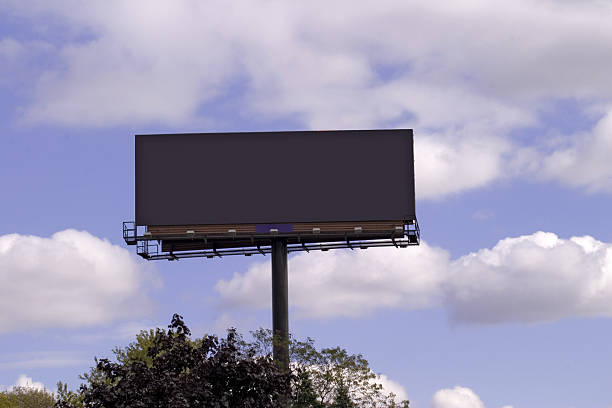 bilboard leere schild auf der wolkig blauer himmel - metal billboard adboard marketing stock-fotos und bilder