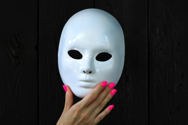 istock female hand holding white mask 1158750039