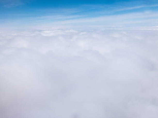 istock Clouds and clear bright blue sky. Aerial view from plane illuminator 1158751305
