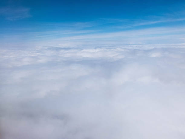 istock Clouds and clear bright blue sky. Aerial view from plane illuminator 1158751376