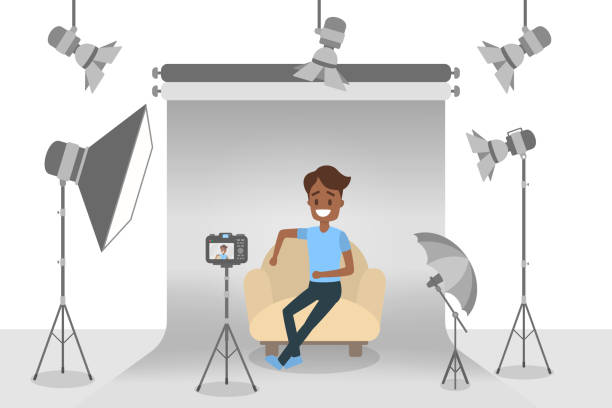 Handsome african american man Handsome african american man in blue t-shirt and black jeans making photoshoot on the grey background with various equipment around such as softbox and camera. Isolated flat vector illustration photo shoot stock illustrations