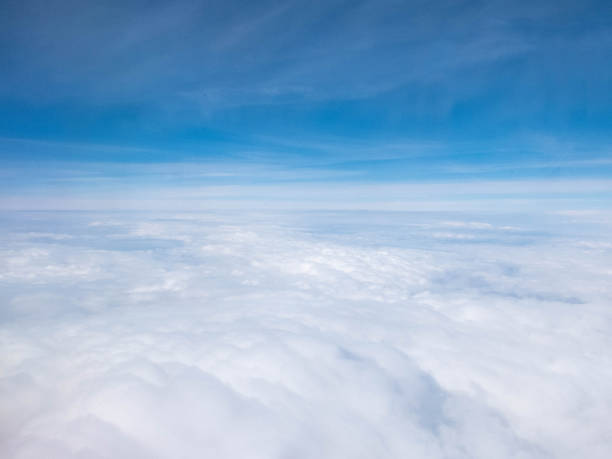 istock Clouds and clear bright blue sky. Aerial view from plane illuminator 1158752771