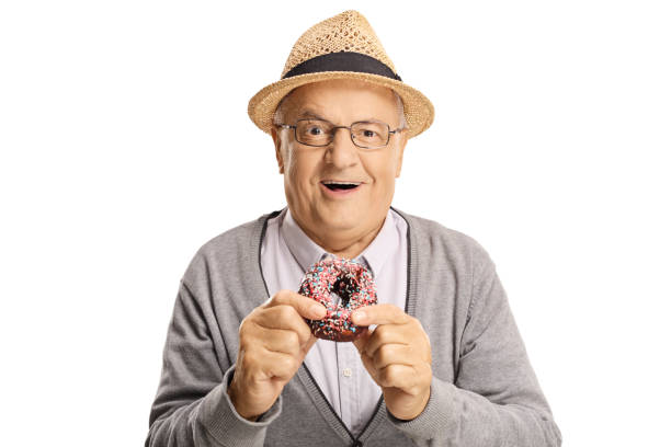 istock Cheerful senior man eating a donut 1158753704