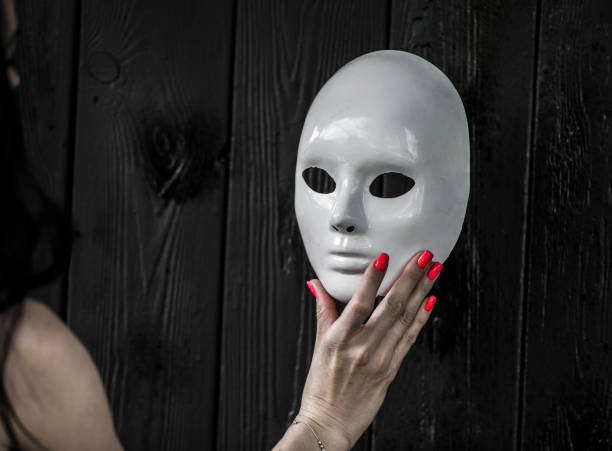 istock female hand holding white mask 1158753819