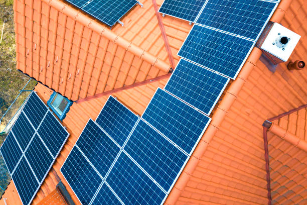 aerial top view of new modern residential house cottage with blue shiny solar photo voltaic panels system on roof. renewable ecological green energy production concept. - voltaic imagens e fotografias de stock