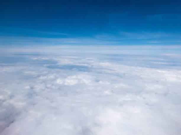 istock Clouds and clear bright blue sky. Aerial view from plane illuminator 1158757100