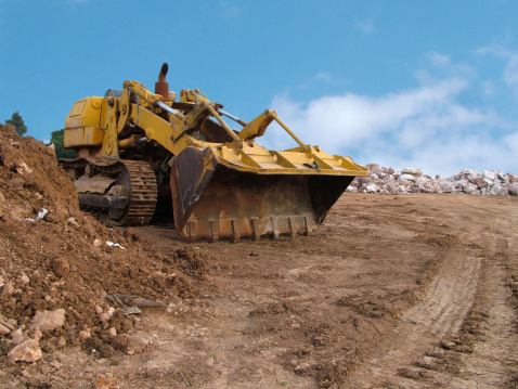 Yellow bulldozer in earthworks.