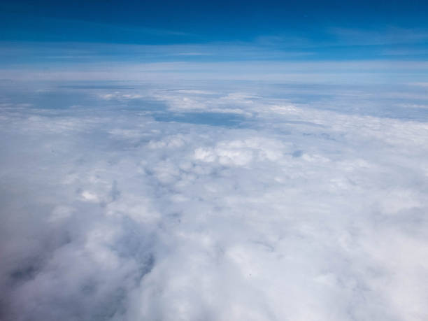 istock Clouds and clear bright blue sky. Aerial view from plane illuminator 1158760994