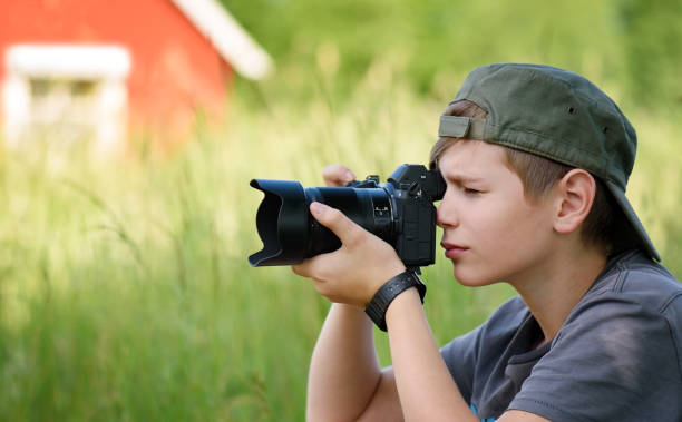 istock Boy shooting nature with SLR camera 1158761181