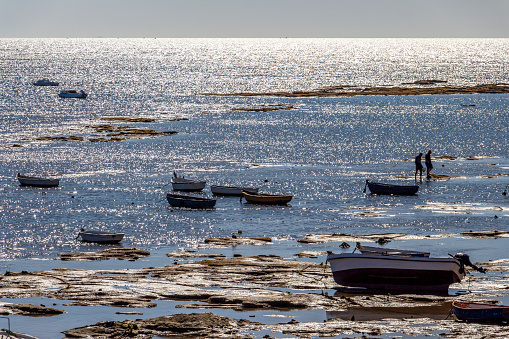 Playa la Caleta or La Caleta Beach shimmering water surface with boats in Cadiz, Province of Cadiz, Andalusia, Spain
