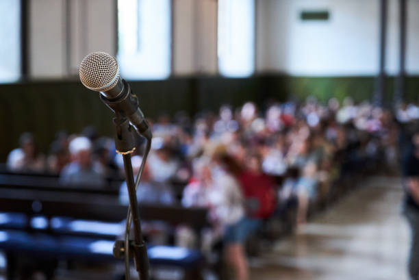 istock Microphone and abstract blurred conference hall or seminar room background 1158763575