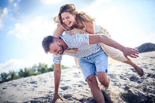 Love is a fun that needs careful attention. Couple on sand.
