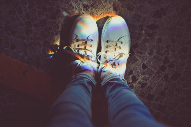 Perspective image of shoes with colorful rainbow highlights on dark background stock photo
