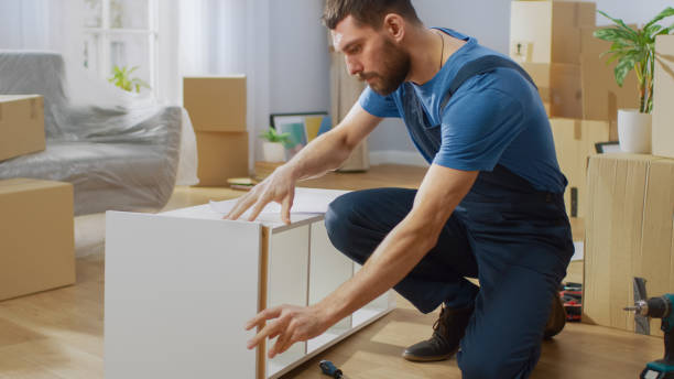 istock Furniture Assembly Worker Assembles Bookshelf. Professional Handyman Doing Assembly Job Well, Helping People who Move into New House. 1158770186