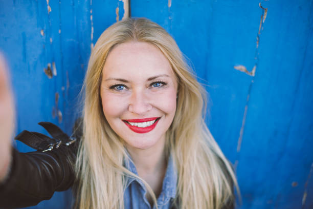 Middle-aged smiling blonde making selfie