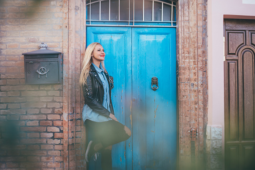 woman posing against blue door