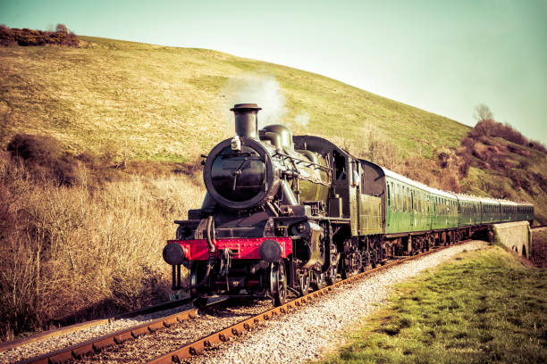 steam train gently moving through the english countryside - steam engine imagens e fotografias de stock