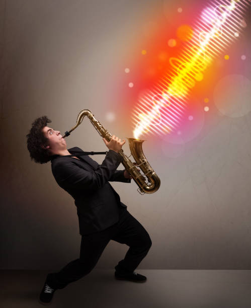 istock Young man playing on saxophone with colorful sound waves 1158774090