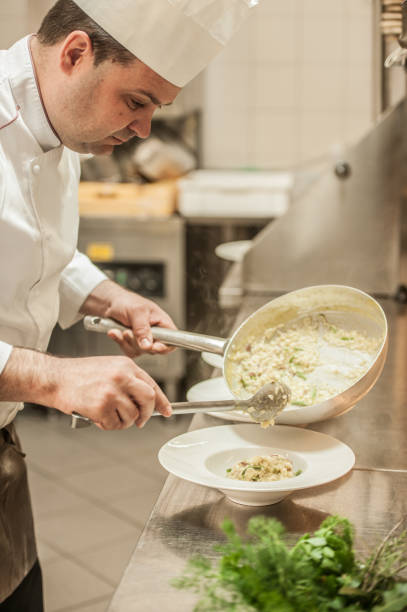 Professional Male Chef Preparing Traditional Italian Risotto with Asparagus