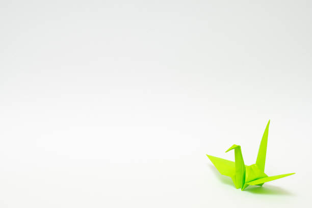 istock light green origami paper crane on white background 1158778748