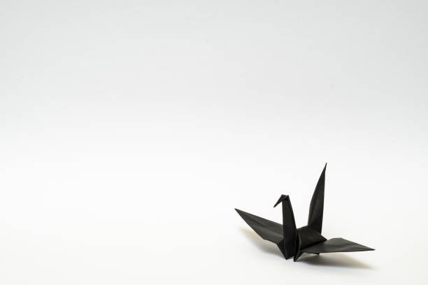 istock black origami paper crane on white background 1158778756