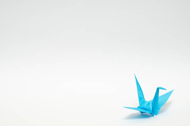 istock light blue origami paper crane on white background 1158778770