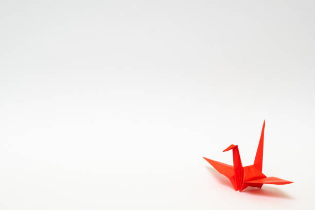 istock red origami paper crane on white background 1158778826