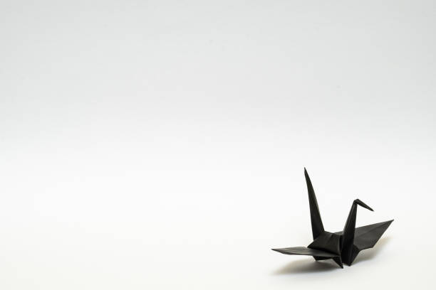 istock black origami paper crane on white background 1158778869