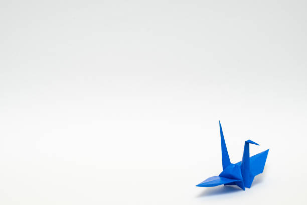 istock blue origami paper crane on white background 1158778872