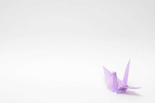 istock light purple origami paper crane on white background 1158778925