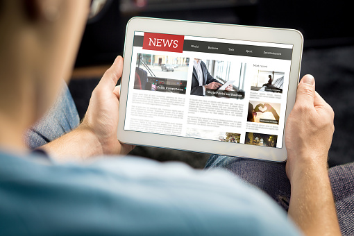 Online news article on tablet screen. Electronic newspaper or magazine. Latest daily press and media. Mockup of digital portal and website. Happy person using web service in the morning.