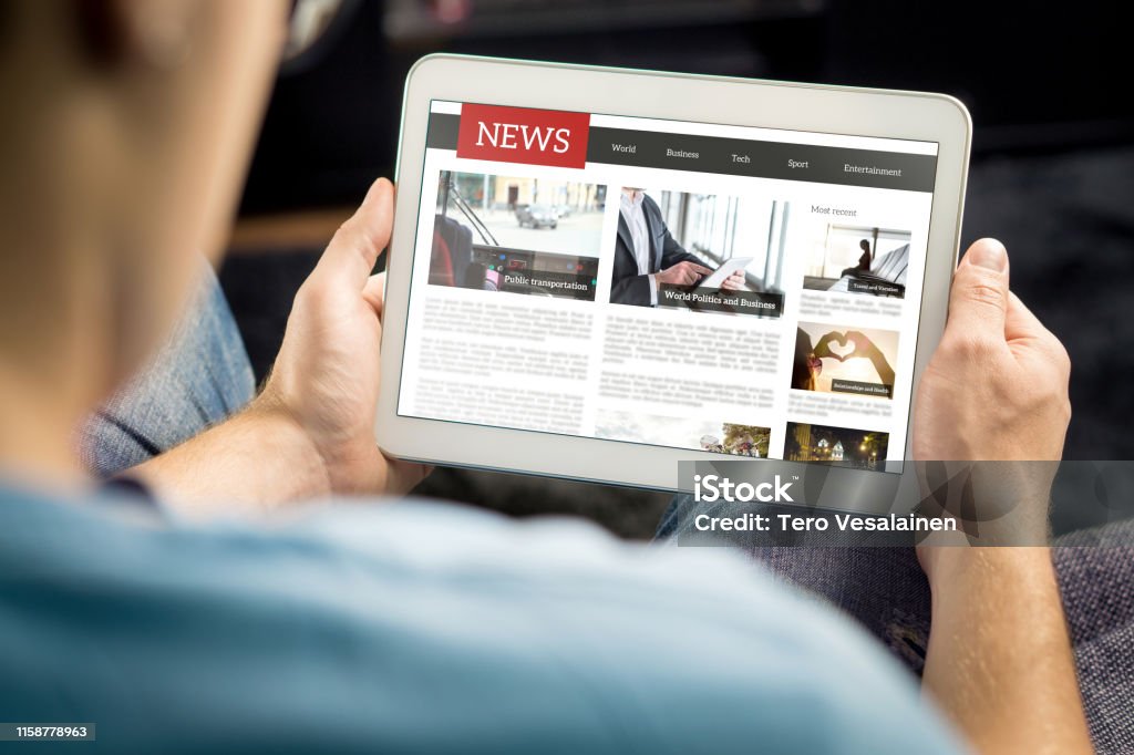 Online news article on tablet screen. Electronic newspaper or magazine. Latest daily press and media. Mockup of digital portal and website. Happy person using web service in the morning. Online news article on tablet screen. Electronic newspaper or magazine. Latest daily press and media. Mockup of digital portal and website. Happy person using web service in the morning. Reading text. Newspaper Stock Photo