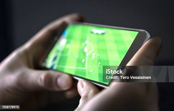 Watching Football And Sport Stream With Mobile Phone Man Streaming Soccer Game Live Video Replay Or Highlights Online With Smart Device Stock Photo - Download Image Now